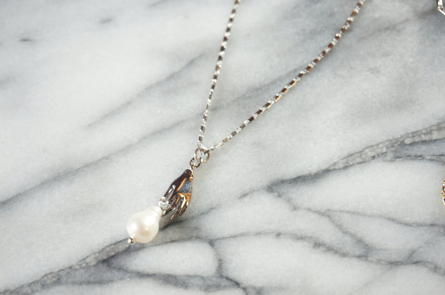 Hand holding pearl-drop necklace / Teardrop Pearl and hands dainty necklace