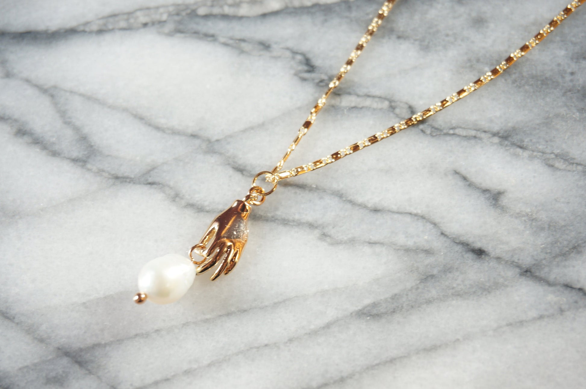 Hand holding pearl-drop necklace / Teardrop Pearl and hands dainty necklace