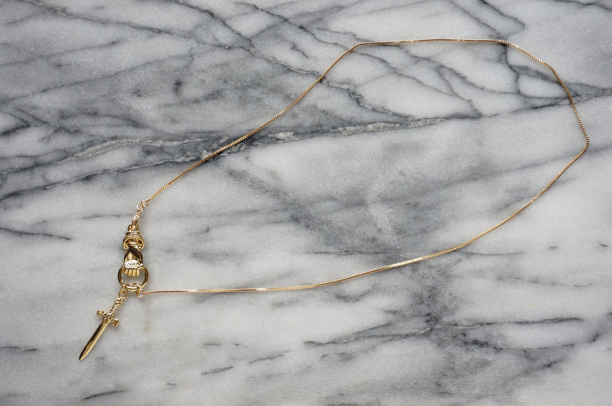 THE HAND Hand Holding Sword Necklace: Gold, Silver, Black Plated Brass Statement Pendant