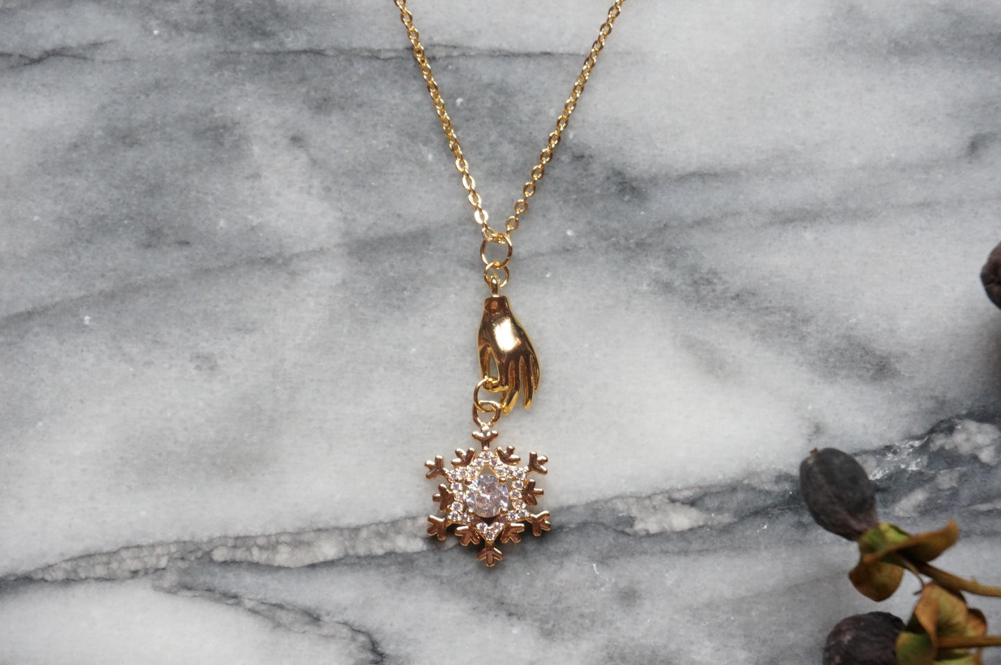 NEVE Gold Plated Hand Holding Snowflake Necklace