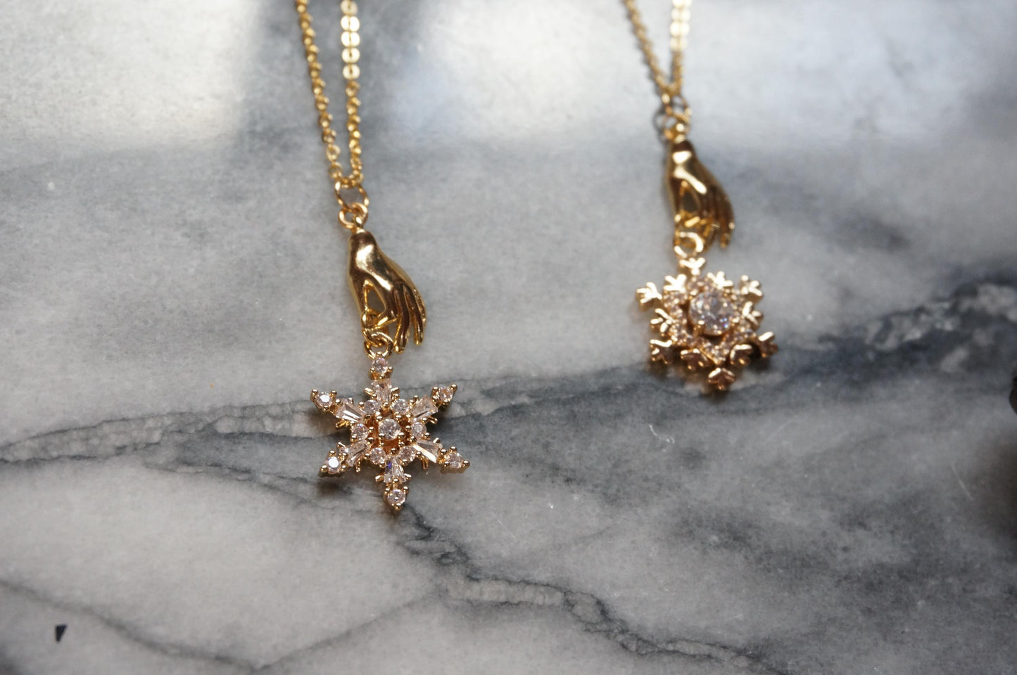 NEVE Gold Plated Hand Holding Snowflake Necklace