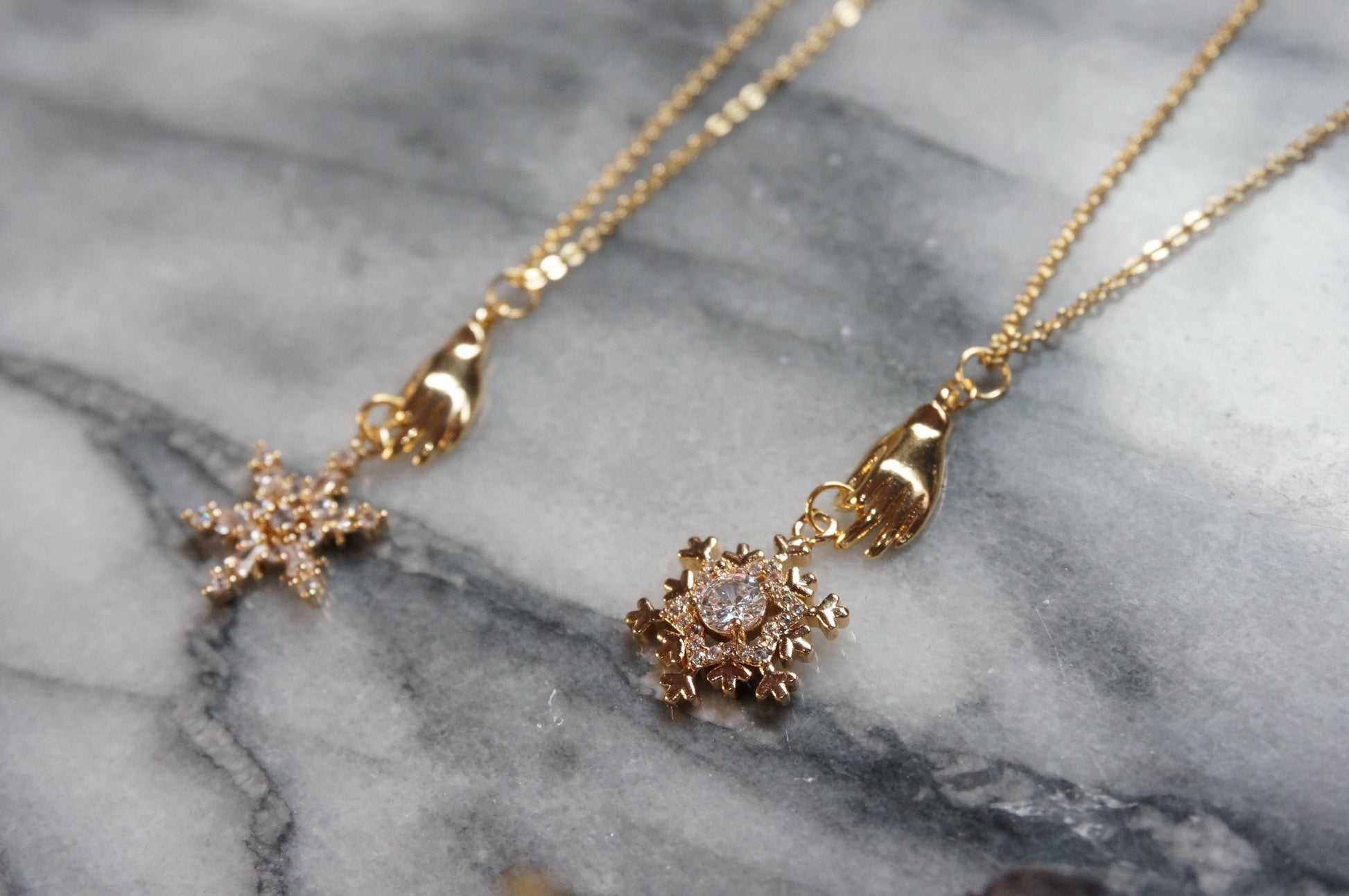 NEVE Gold Plated Hand Holding Snowflake Necklace