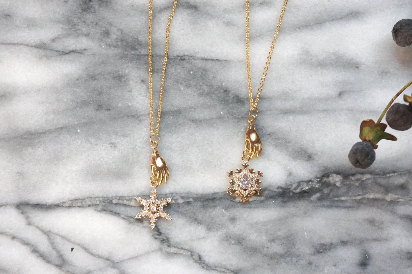 NEVE Gold Plated Hand Holding Snowflake Necklace