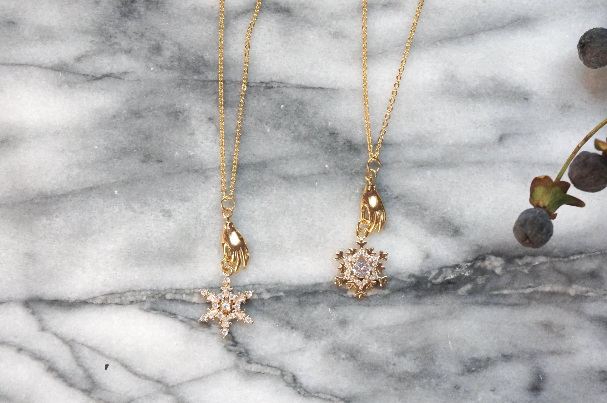 NEVE Gold Plated Hand Holding Snowflake Necklace