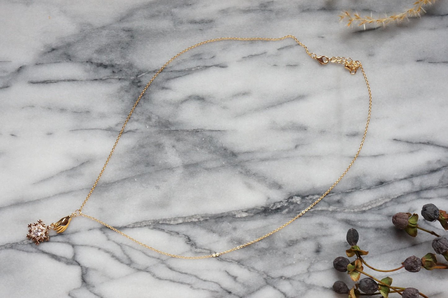 NEVE Gold Plated Hand Holding Snowflake Necklace
