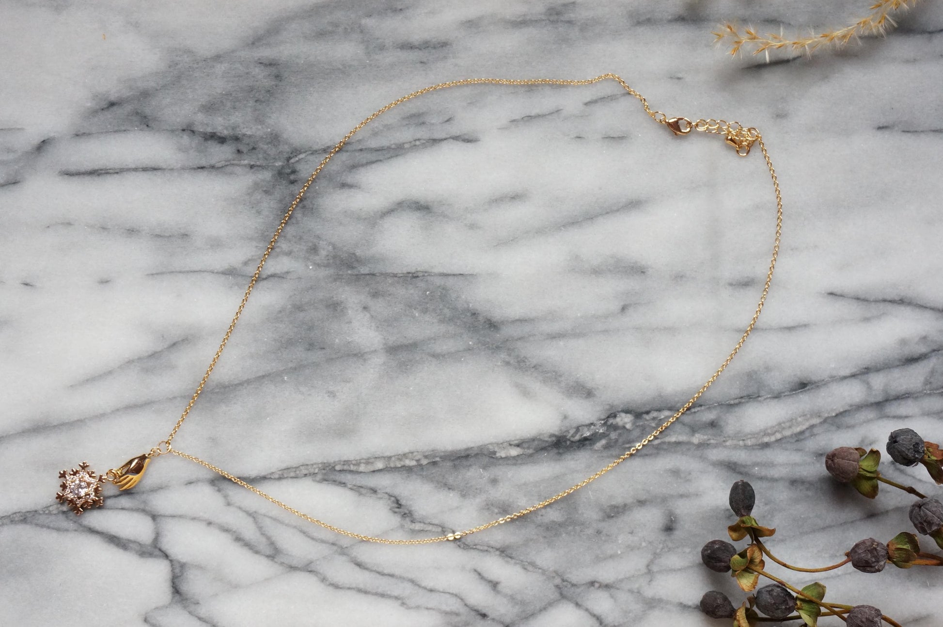 NEVE Gold Plated Hand Holding Snowflake Necklace