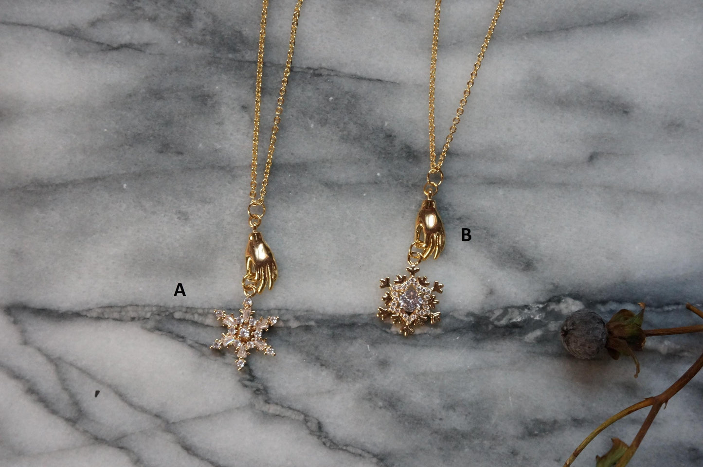 NEVE Gold Plated Hand Holding Snowflake Necklace