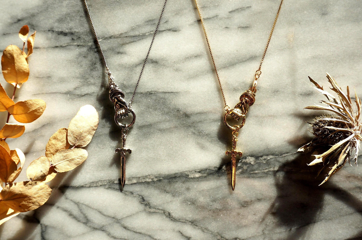THE HAND Hand Holding Sword Necklace: Gold, Silver, Black Plated Brass Statement Pendant